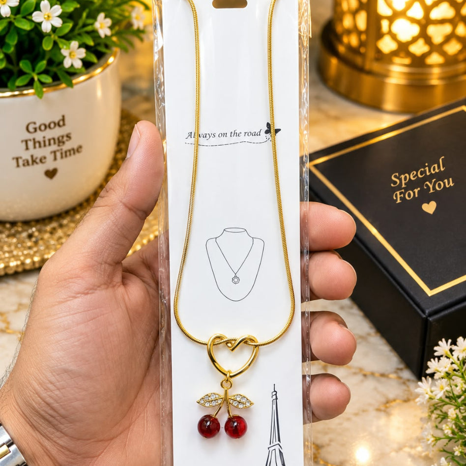 Gold tone heart and red stone cherry necklace styled for women by Rivaalane
