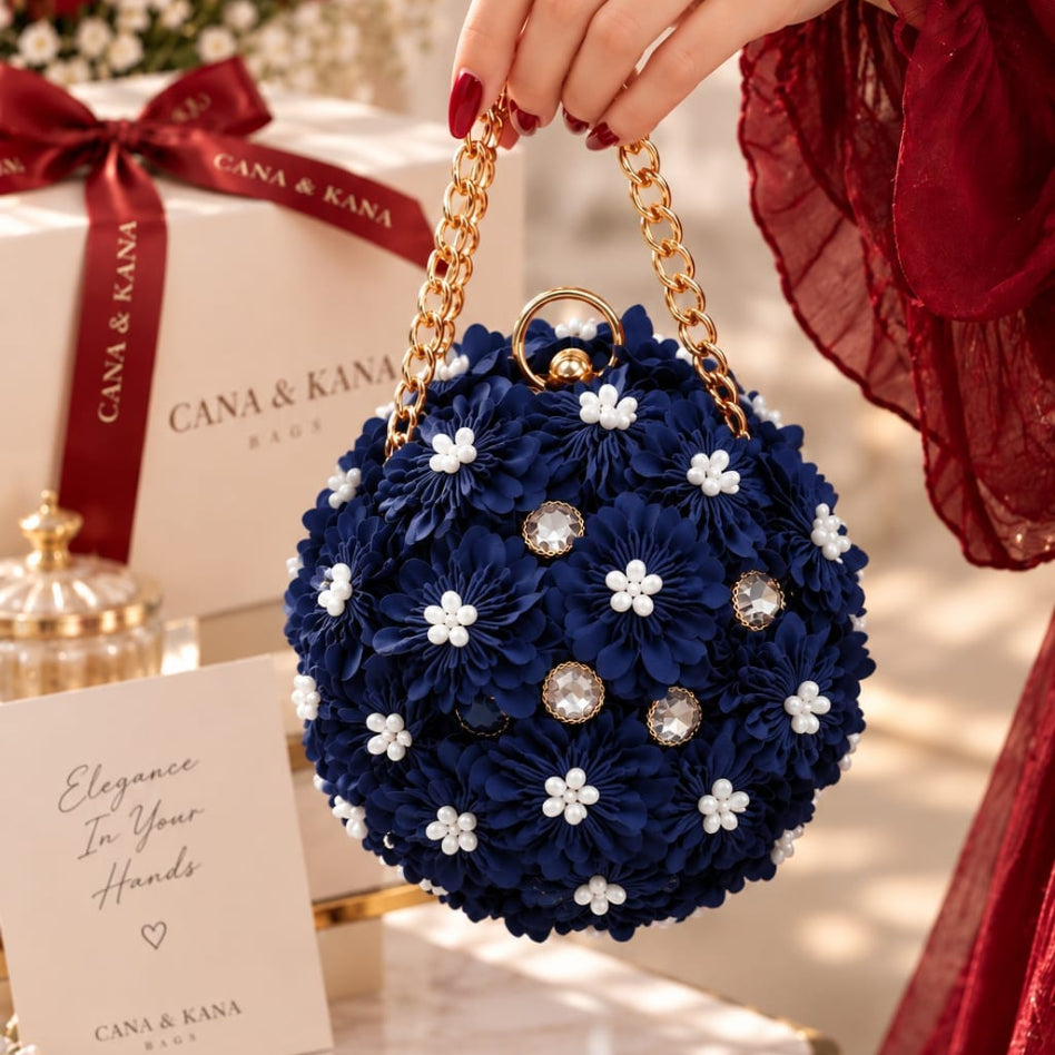 navy blue floral ball purse with white flower accents and gold chain straps